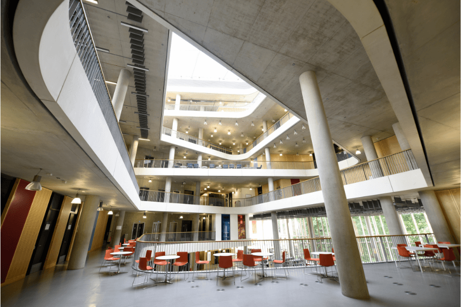 Modern and clean common area in a multi-storey building with open spaces and seating areas.